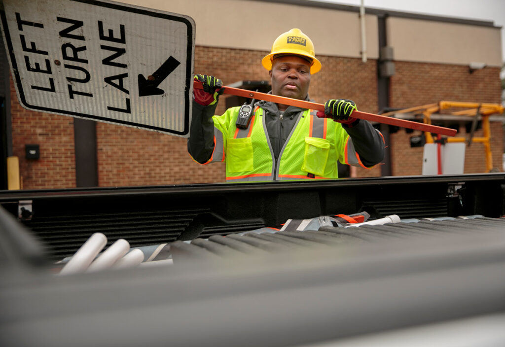 Rickey Goodwin loading sign in truck bed