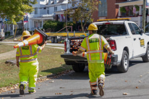 Two employees carrying cone to truck