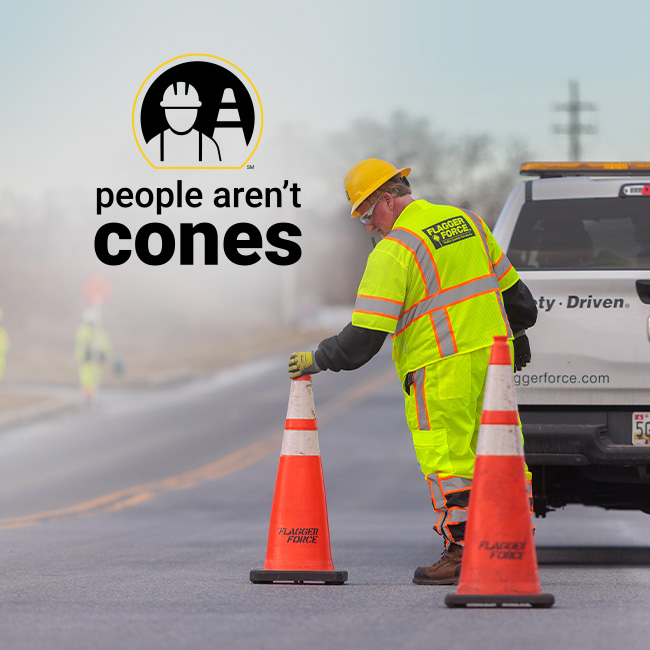 Flagger Force crew member dressed in high-visibility yellow placing a cone.